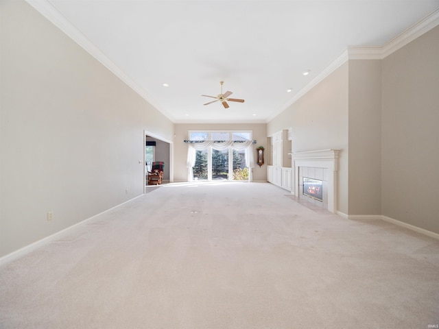 unfurnished living room featuring crown molding, light colored carpet, a fireplace, and ceiling fan