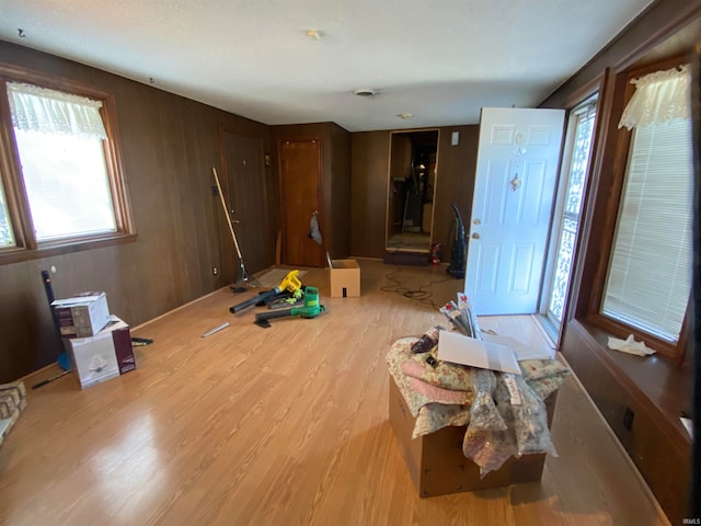 living area with light wood-style floors and wooden walls