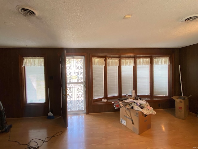 entryway with light wood-style flooring, visible vents, and a textured ceiling