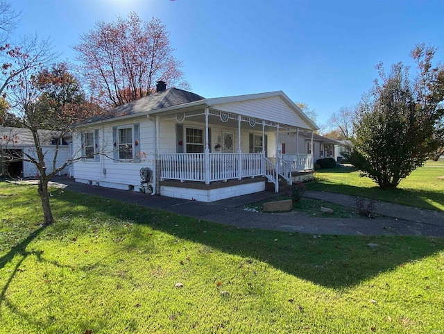 view of front of home with a chimney, a porch, and a front yard