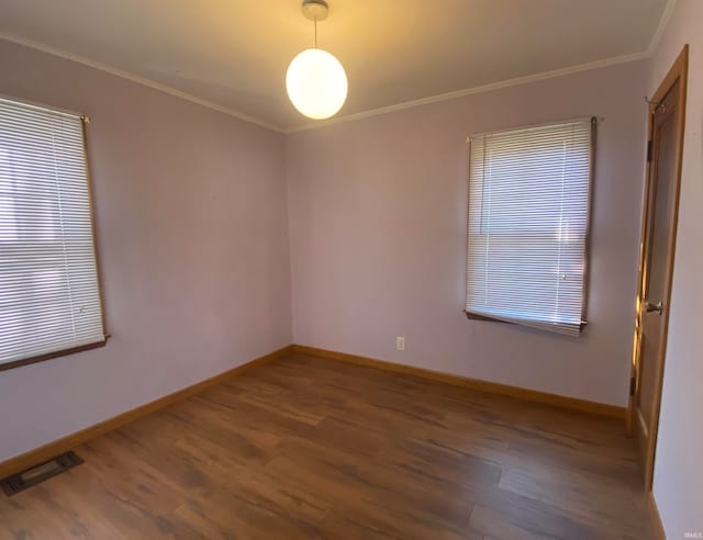 unfurnished room featuring dark wood-style floors, visible vents, and crown molding