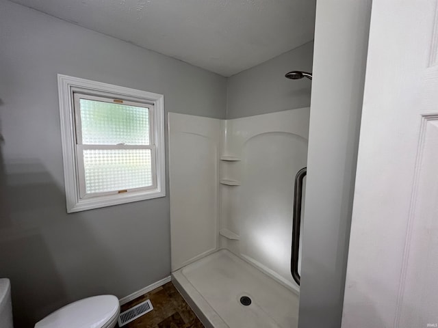 bathroom featuring toilet and walk in shower