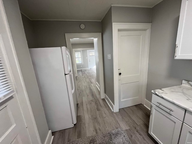 kitchen featuring white cabinetry, light wood-type flooring, and white refrigerator