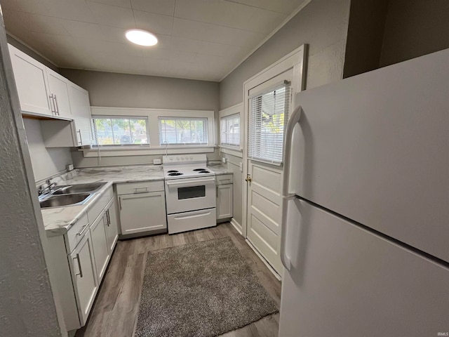 kitchen with a healthy amount of sunlight, dark wood-type flooring, white cabinets, and white appliances