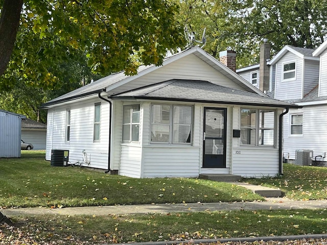 view of front facade featuring central AC and a front yard