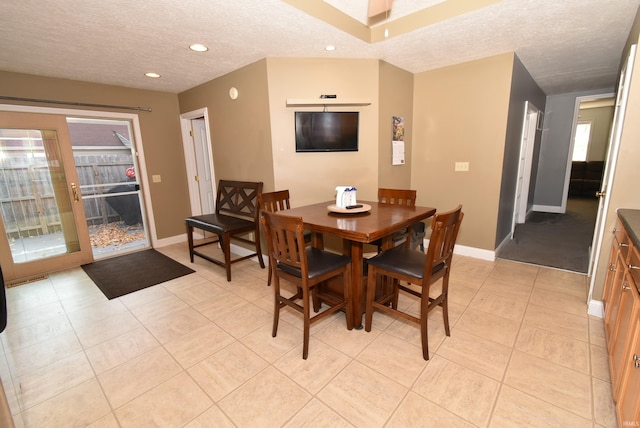 dining area with a textured ceiling and light tile patterned floors