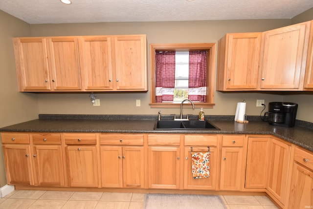 kitchen featuring sink, a textured ceiling, and light tile patterned floors