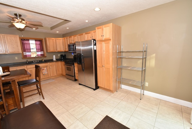 kitchen featuring a textured ceiling, stainless steel appliances, light tile patterned floors, and ceiling fan