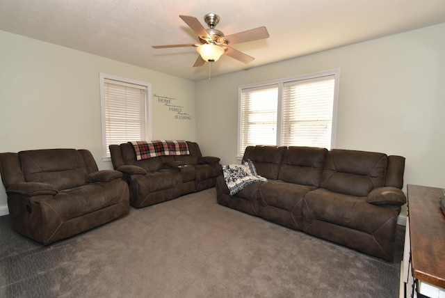 living room featuring ceiling fan and dark carpet