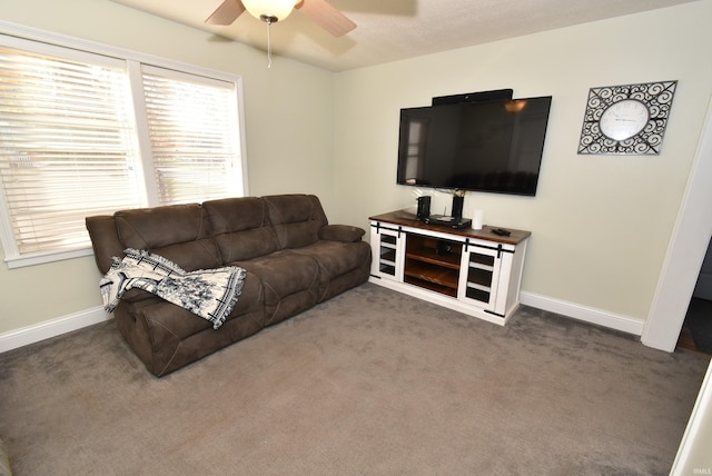 living room featuring ceiling fan and dark colored carpet