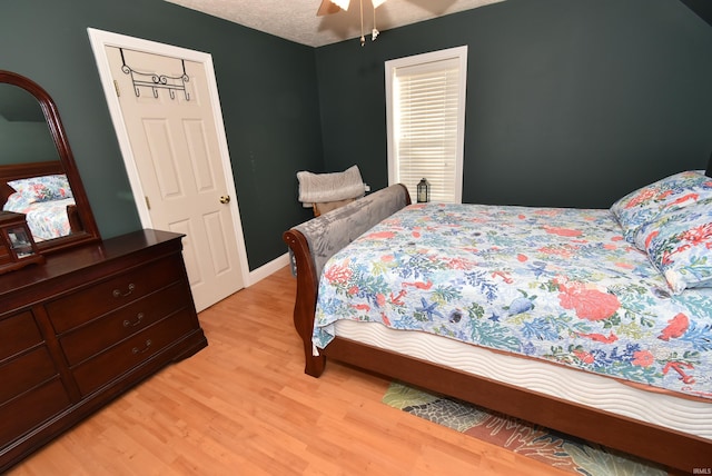 bedroom featuring a textured ceiling, light hardwood / wood-style floors, and ceiling fan