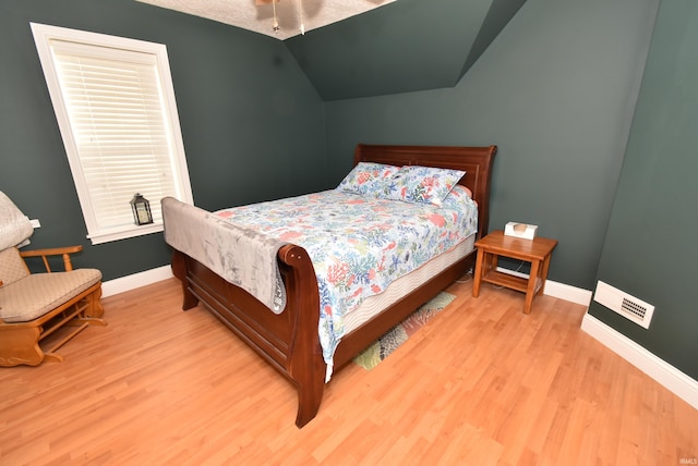 bedroom with vaulted ceiling and light wood-type flooring