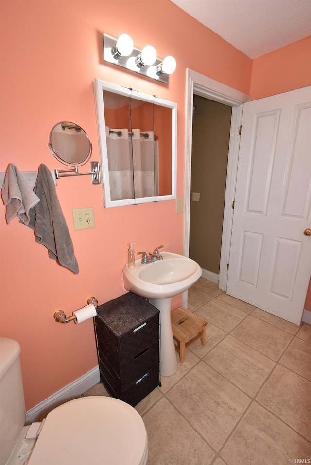 bathroom featuring toilet and tile patterned flooring