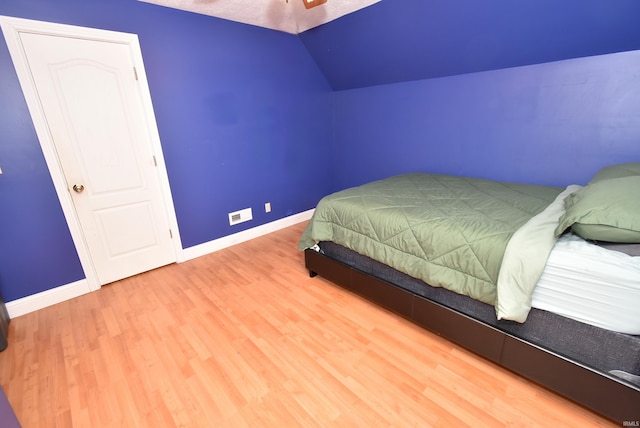 bedroom with hardwood / wood-style flooring and vaulted ceiling