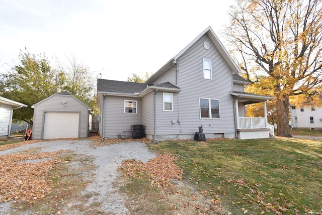 rear view of property with a yard, an outdoor structure, and a garage