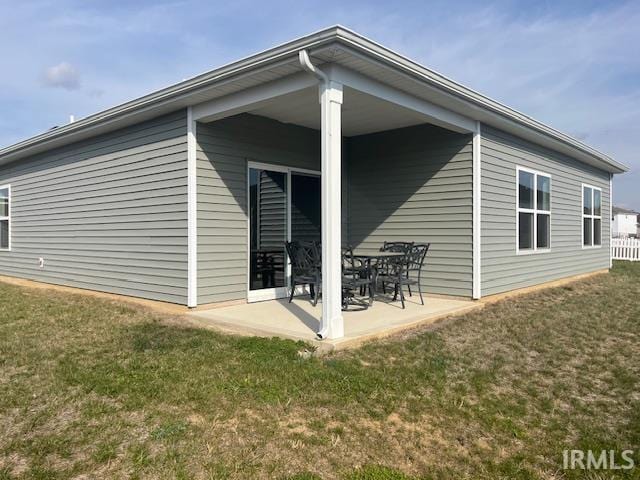 rear view of house featuring a yard and a patio