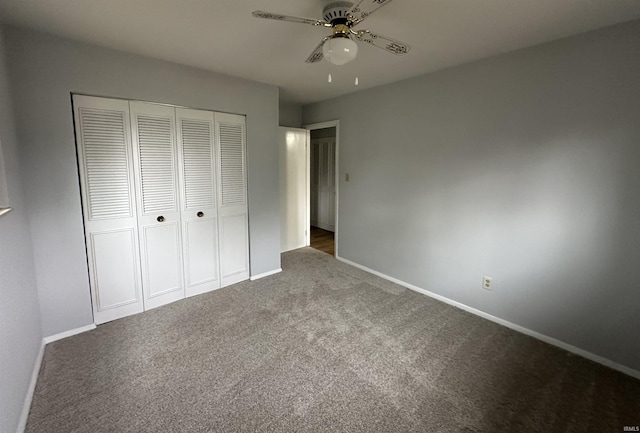 unfurnished bedroom with a closet, ceiling fan, and dark colored carpet