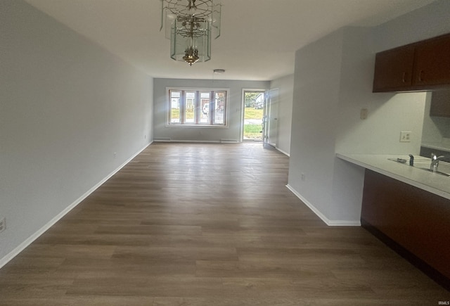 unfurnished dining area with an inviting chandelier, hardwood / wood-style flooring, built in desk, and sink