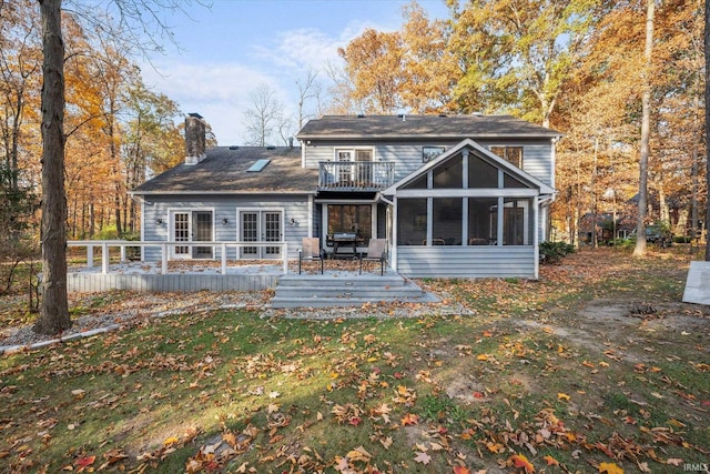 back of property with a sunroom and a deck