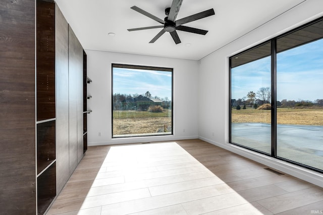 spare room featuring ceiling fan and light hardwood / wood-style flooring