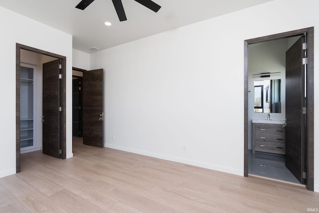 unfurnished bedroom featuring light hardwood / wood-style flooring, ensuite bath, and ceiling fan