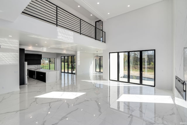 living room featuring french doors, sink, and a high ceiling