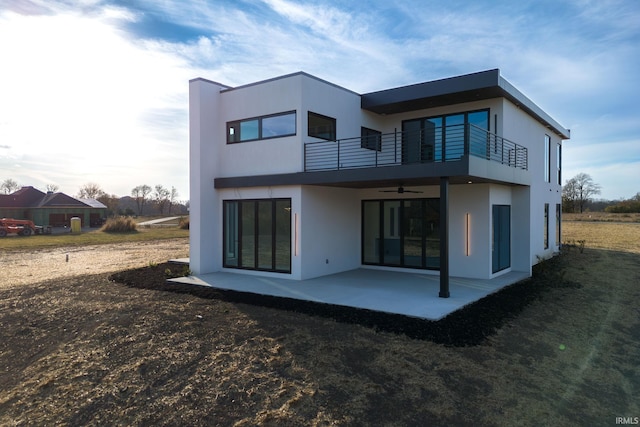 back of house with a balcony, a patio area, and ceiling fan