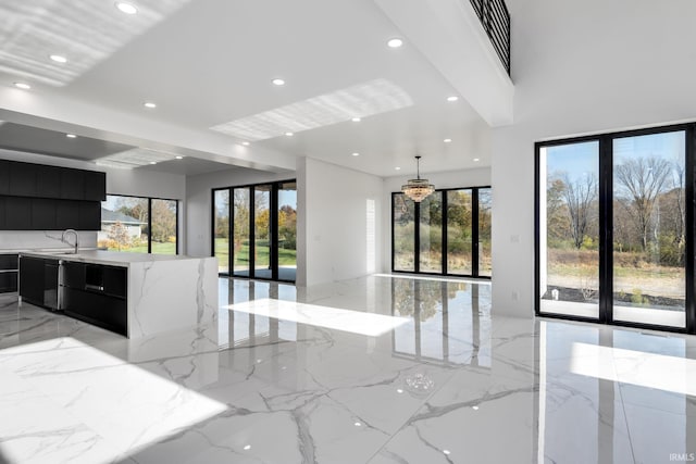 kitchen with light stone countertops, sink, and decorative light fixtures