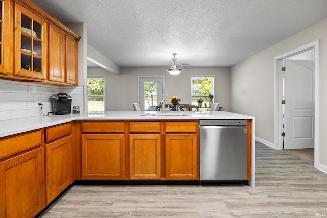 kitchen with tasteful backsplash, sink, kitchen peninsula, light hardwood / wood-style floors, and stainless steel dishwasher