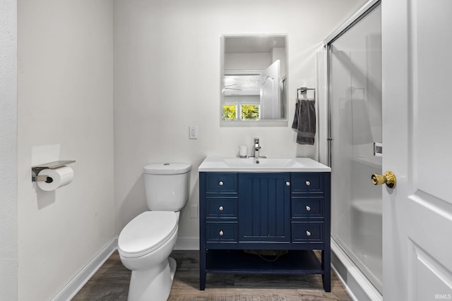 bathroom featuring toilet, hardwood / wood-style floors, walk in shower, and vanity