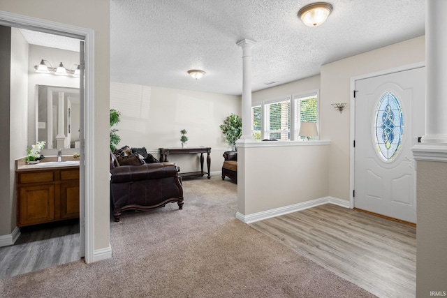 entryway featuring sink, a textured ceiling, and light hardwood / wood-style floors