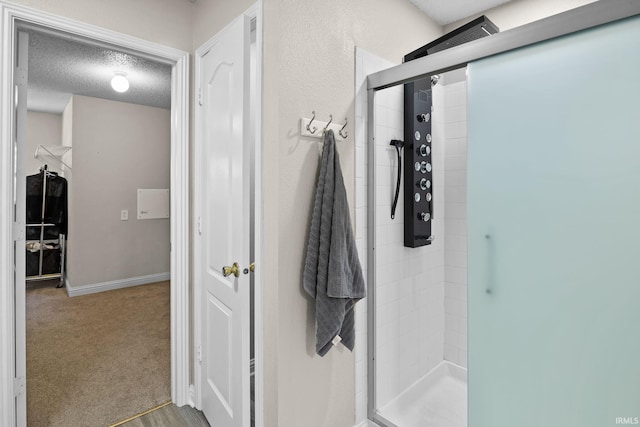 bathroom with a textured ceiling and a shower with shower door