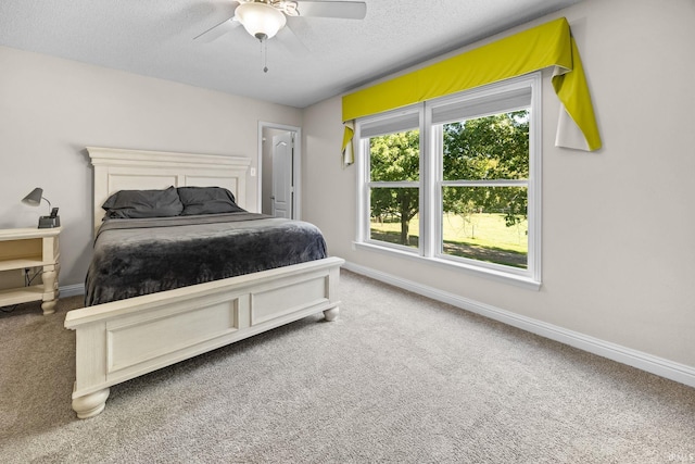 carpeted bedroom with ceiling fan and a textured ceiling