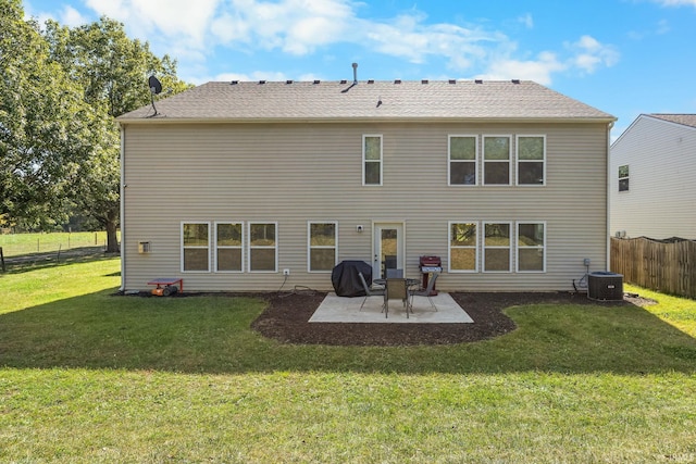 back of property with a yard, central air condition unit, and a patio area