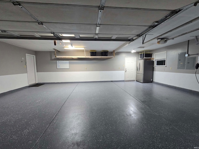 garage featuring a garage door opener, electric panel, and stainless steel fridge