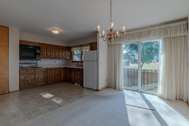 kitchen with a chandelier, a healthy amount of sunlight, sink, and white refrigerator
