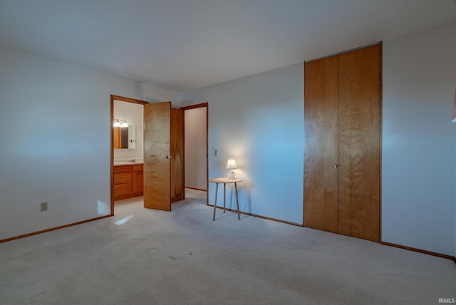 unfurnished bedroom featuring connected bathroom, light carpet, and a closet