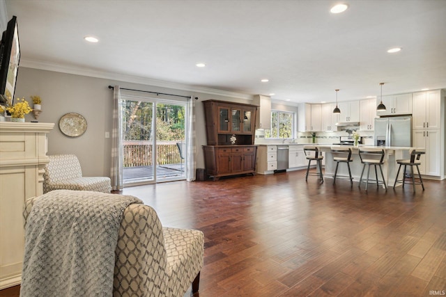 living room featuring ornamental molding, sink, and dark hardwood / wood-style flooring