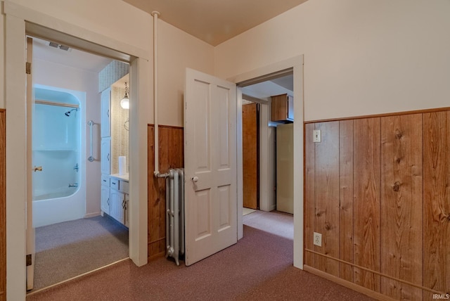 hall with wooden walls and carpet floors