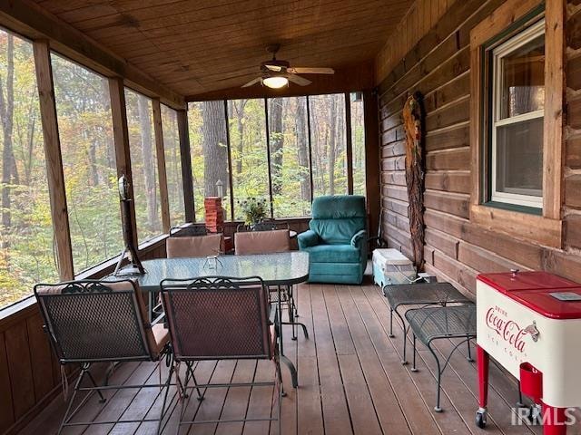 sunroom / solarium with ceiling fan, wooden ceiling, and a wealth of natural light