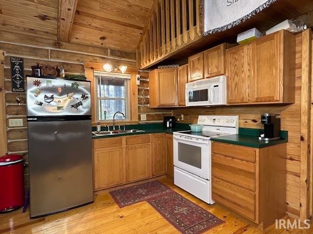 kitchen featuring white appliances, wood walls, sink, wooden ceiling, and light hardwood / wood-style flooring