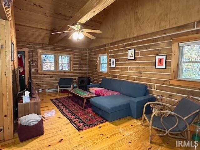 living room featuring wood ceiling, wooden walls, hardwood / wood-style floors, lofted ceiling with beams, and ceiling fan