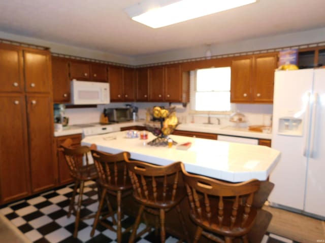 kitchen featuring a kitchen island, a breakfast bar, and white appliances