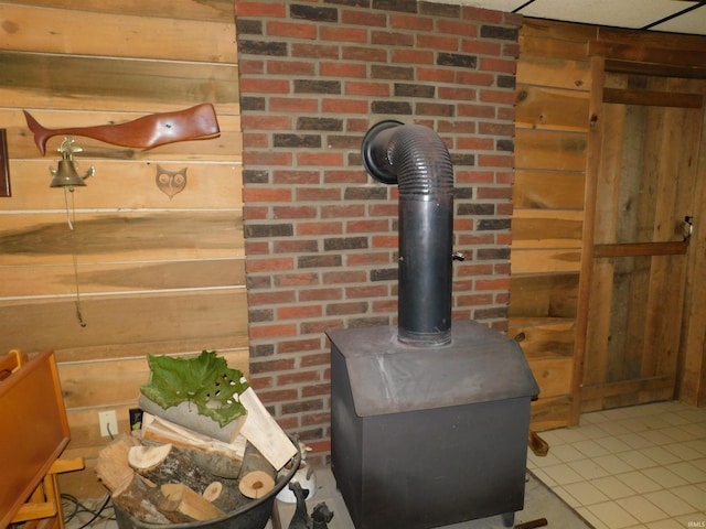 details with wooden walls, a wood stove, and tile patterned flooring