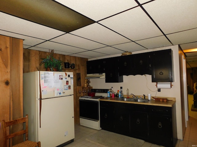 kitchen with wood walls, sink, a paneled ceiling, and white appliances