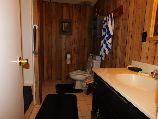 bathroom with vanity, toilet, tile patterned floors, and wooden walls