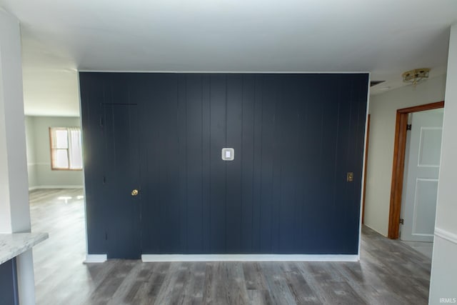 interior space with wood walls and hardwood / wood-style flooring