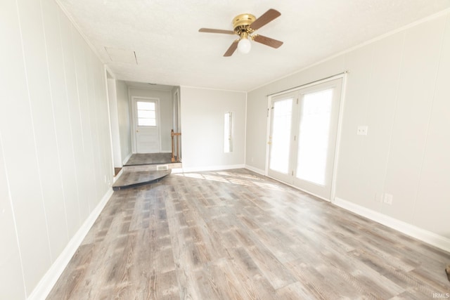 unfurnished living room with crown molding, light wood-type flooring, and ceiling fan