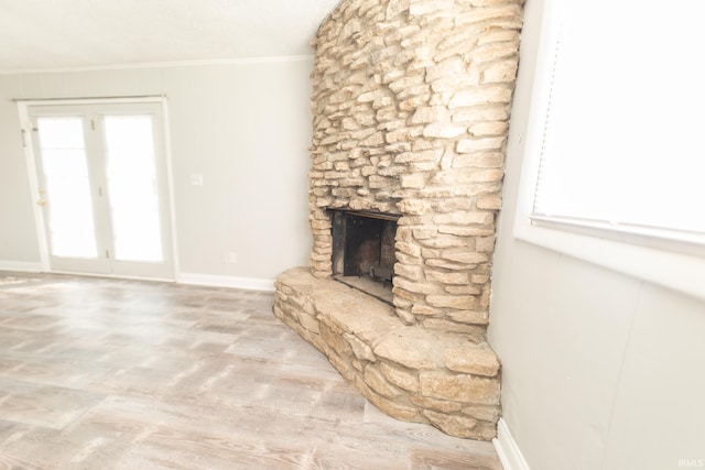 unfurnished living room featuring crown molding and a stone fireplace