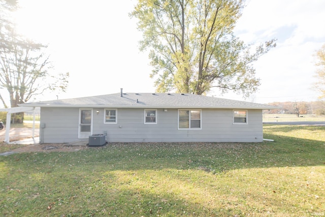 back of property with a yard and central AC unit